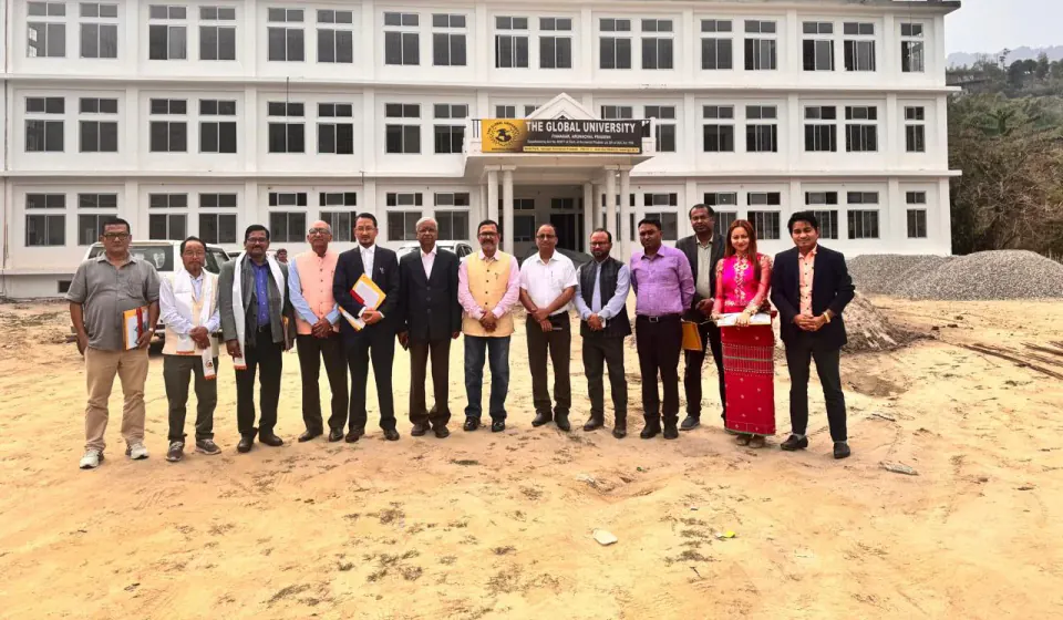 A group standing outside The Global University campus building